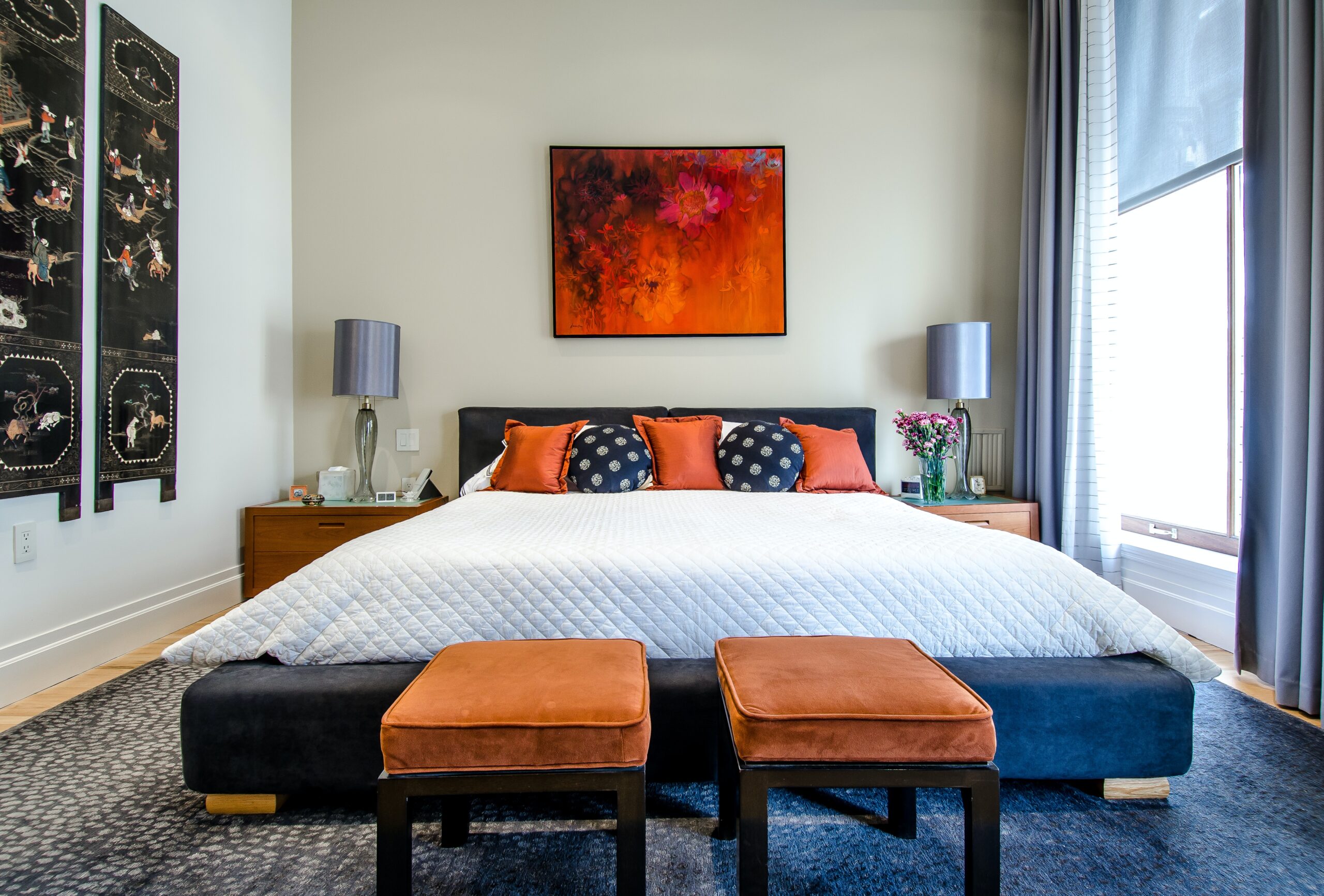 Quilited White Comforter with Orange Pillows in Bedroom